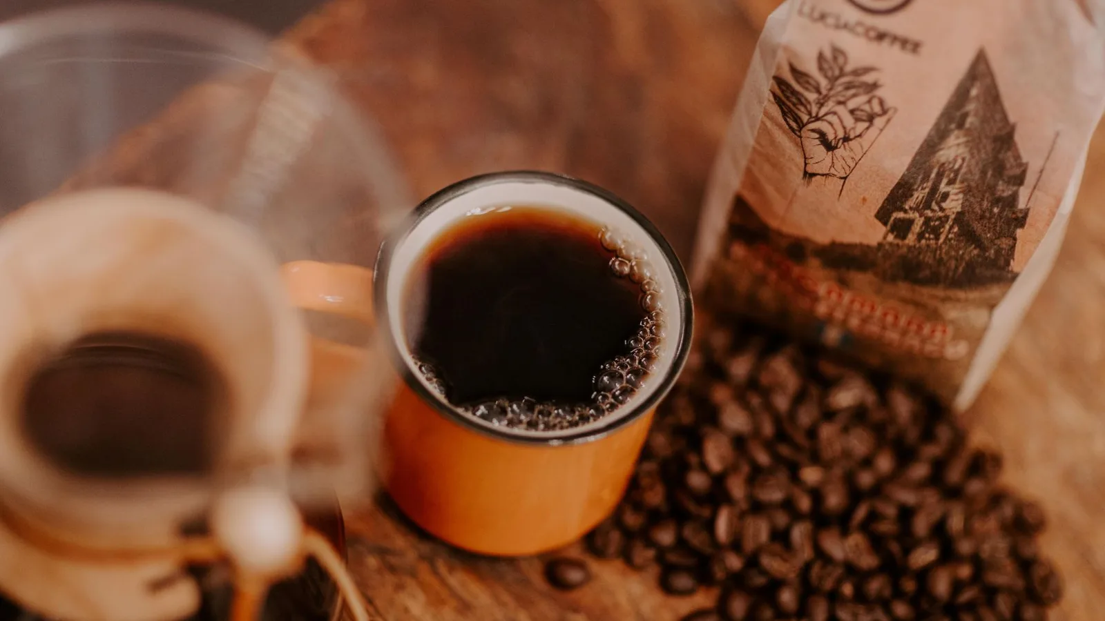 A close-up shot of freshly brewed coffee in a ceramic mug with coffee beans from Huehuetenango, Guatemala.
