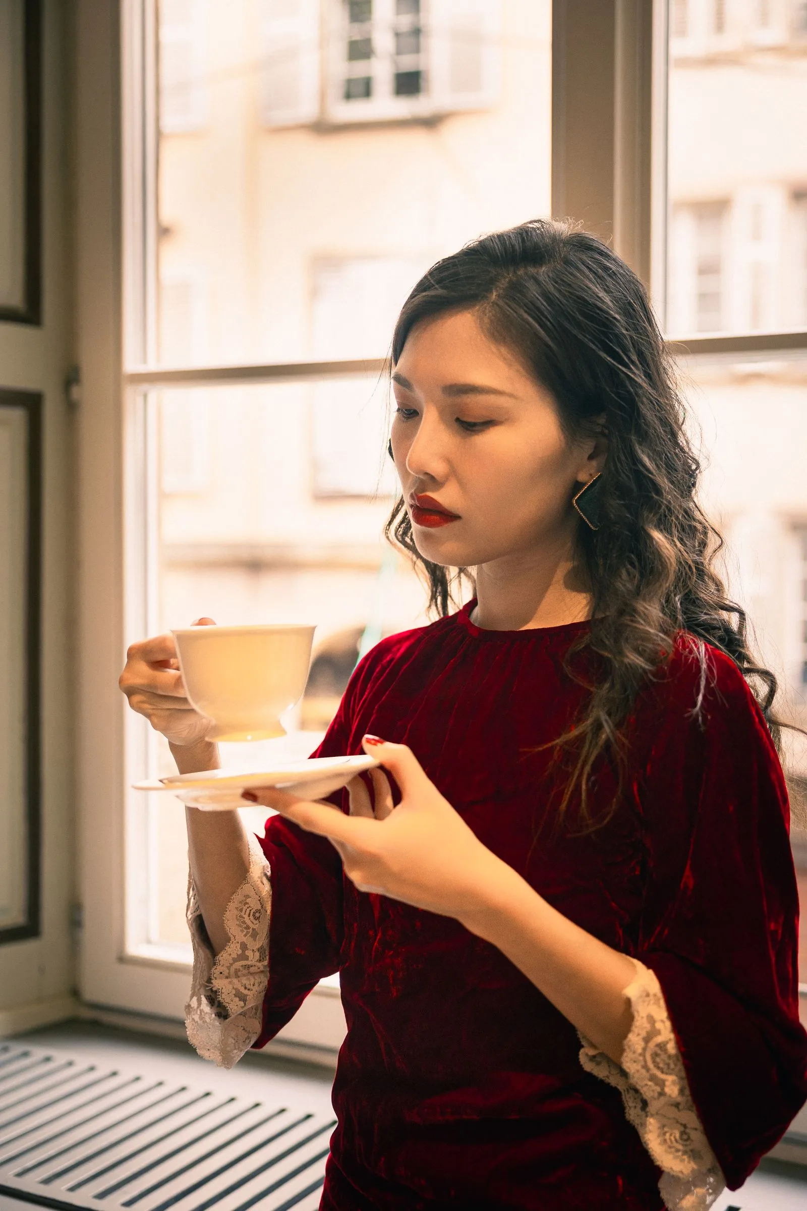 Woman grimacing with discomfort beside an untouched cup of coffee on the table