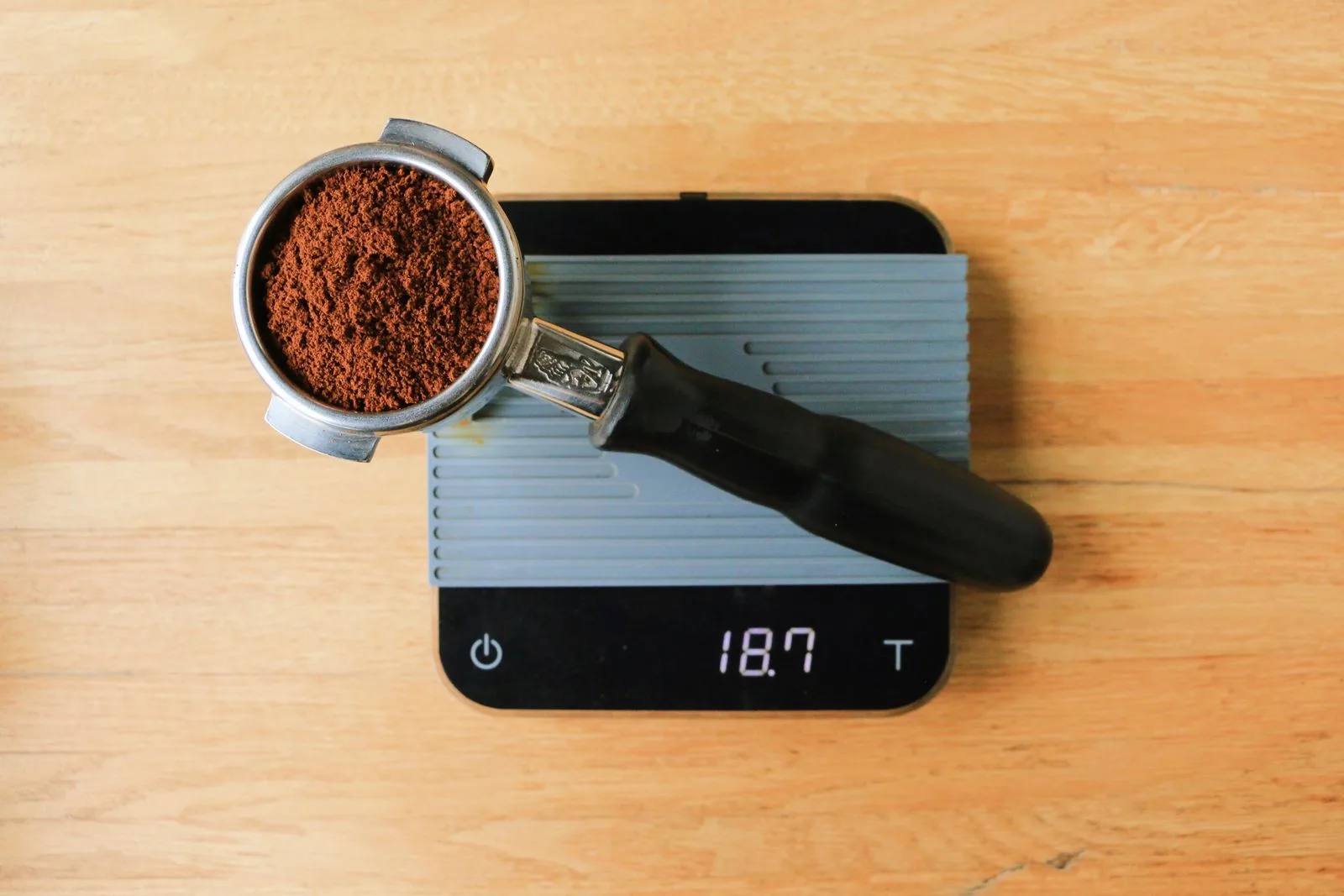 Ground coffee being weighed on a digital kitchen scale before brewing