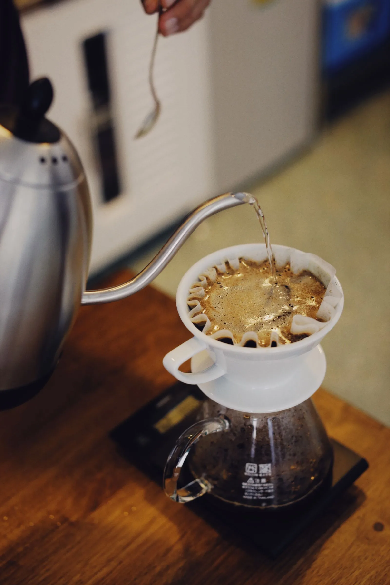 Water being poured into a coffee maker's glass carafe against its marked fill lines