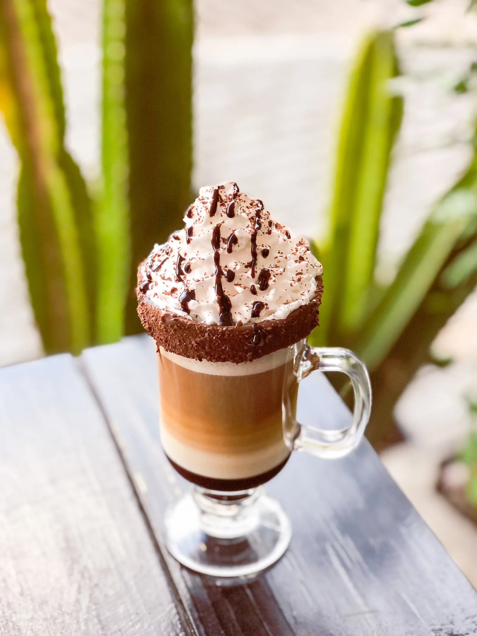 Chocolate coffee drink topped with whipped cream in a cafe mug