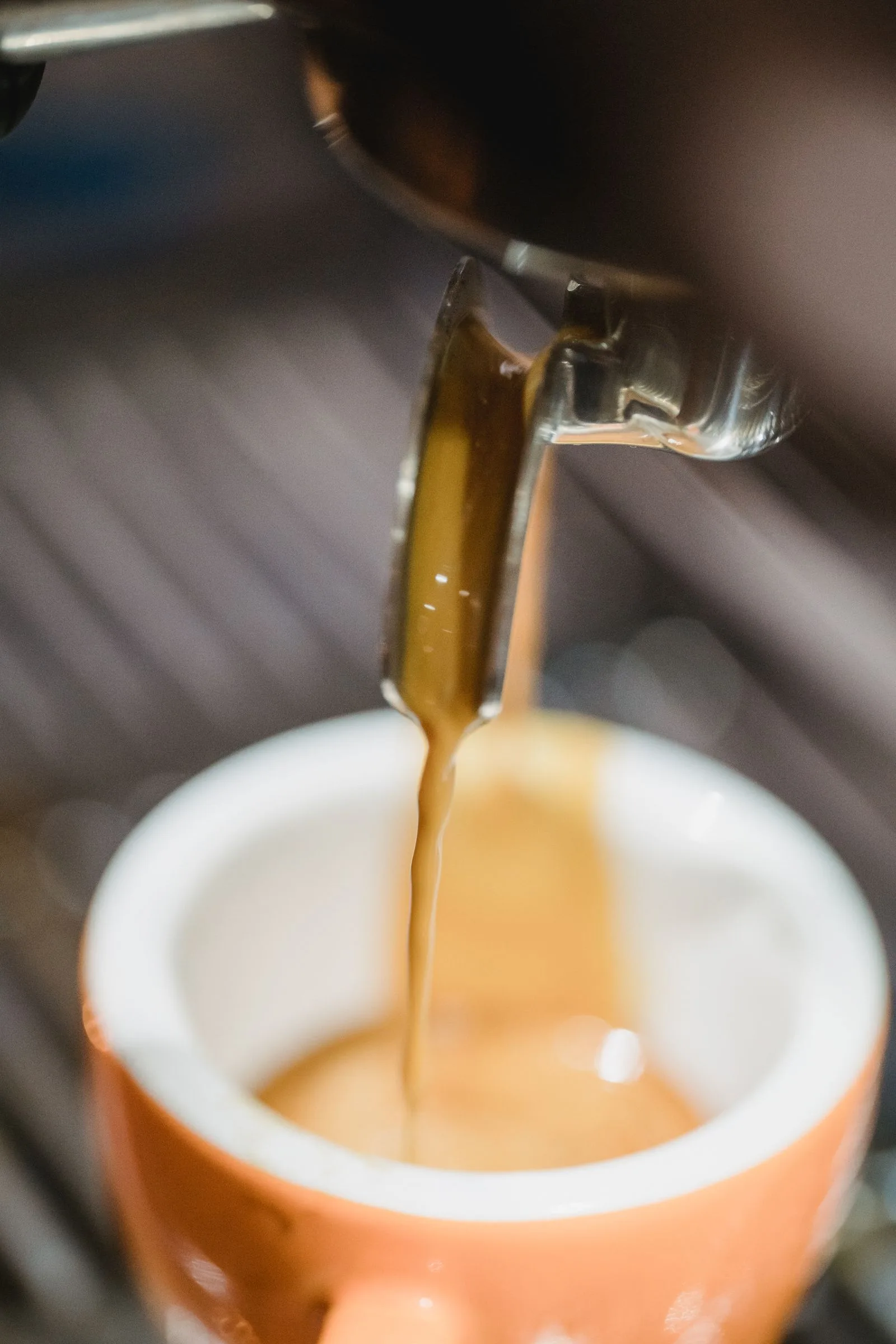 Espresso stream spraying unevenly from a channeled portafilter basket