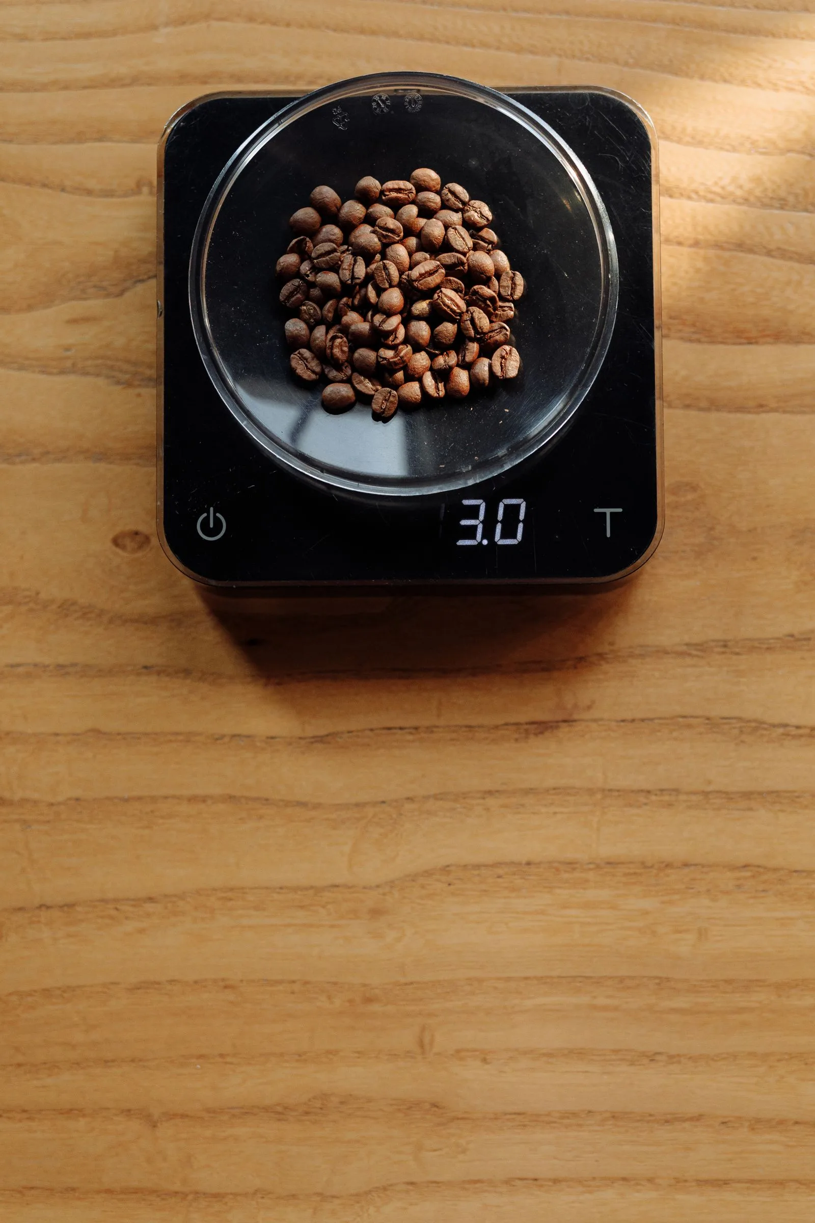 Barista placing a portafilter on a scale to weigh an espresso shot