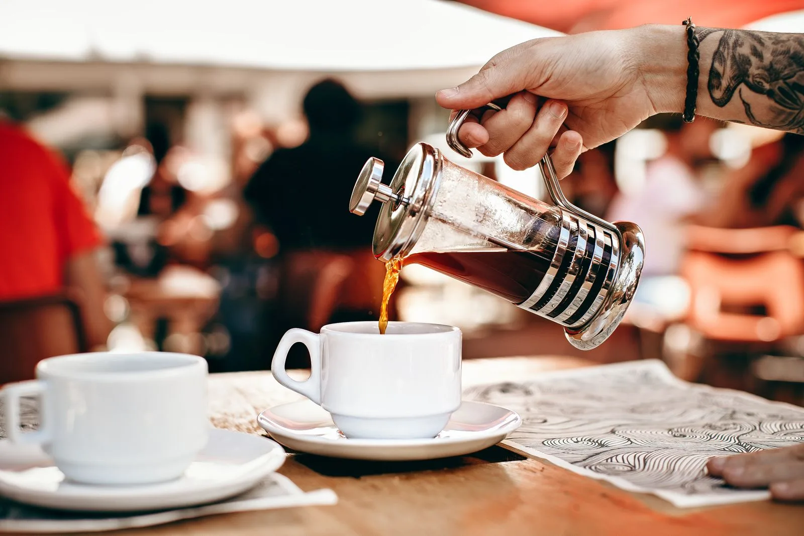 Pouring hot water into a French press filled with ground coffee