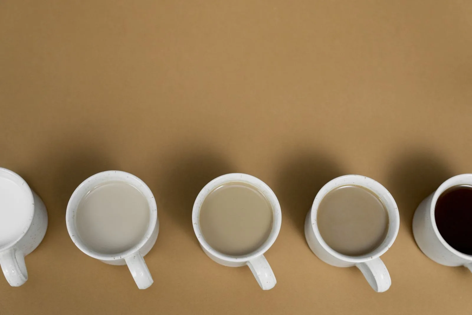 Three cups of coffee displaying different brew strengths and colors