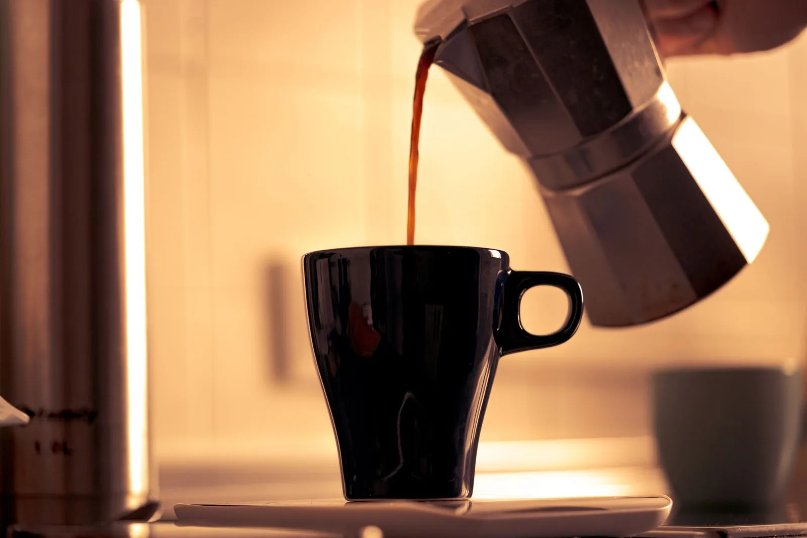 Pouring freshly brewed French press coffee into a ceramic cup