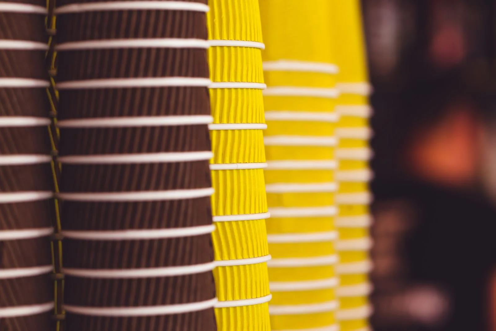 Assorted disposable coffee cups from major coffee chains lined up together